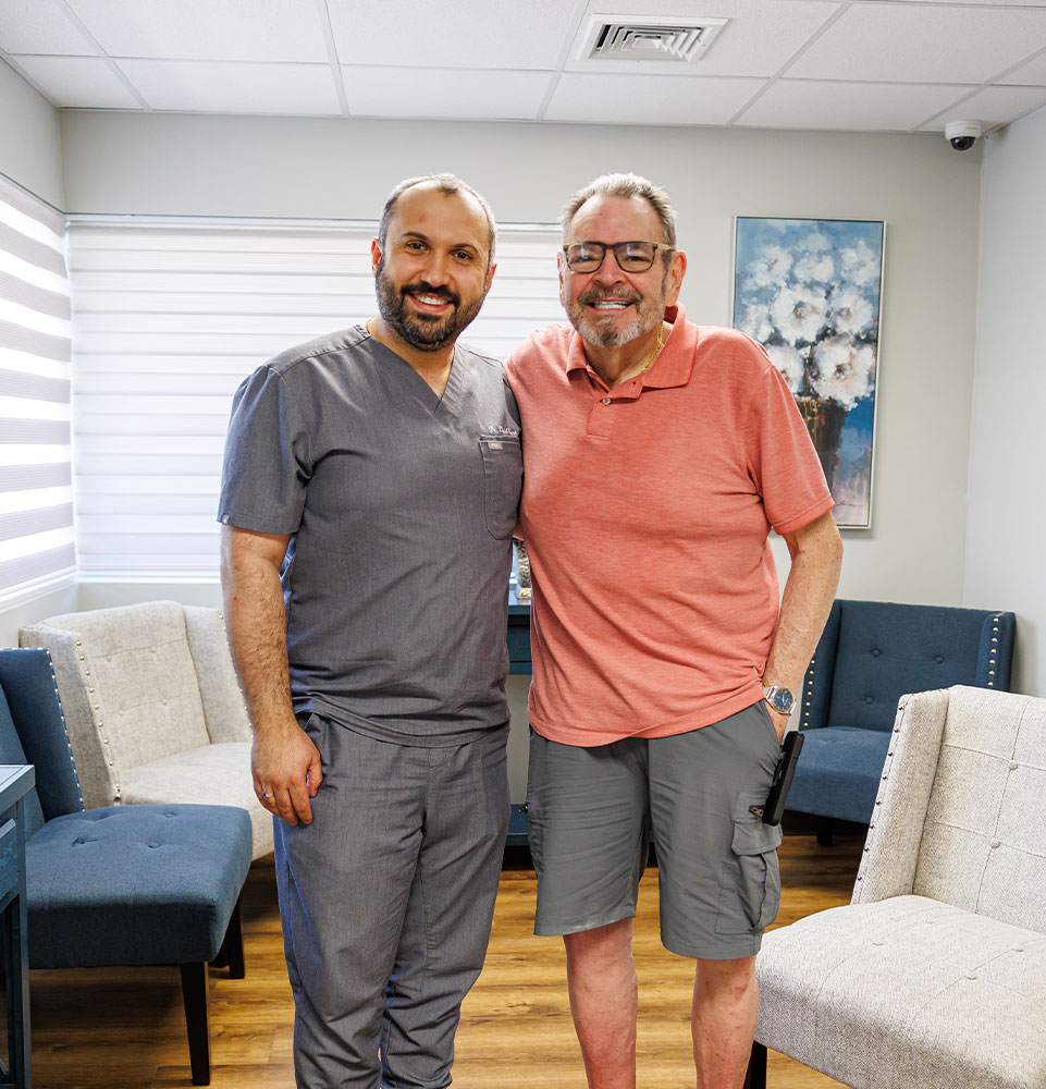 doctor and patient smiling together within the lobby of the dental center